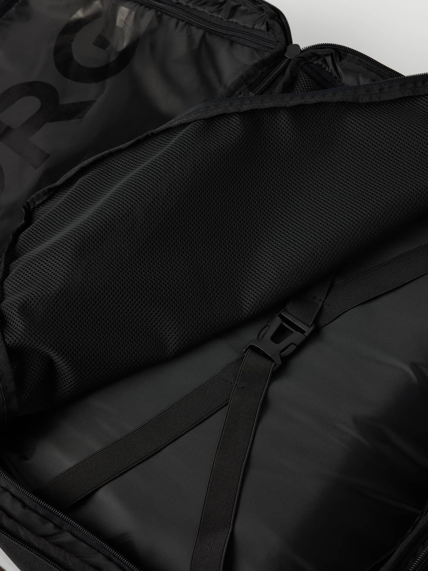 Interior view of the black lining and packing straps in the Borg Travel Backpack L - 35L in Bone White (White). - Image 3