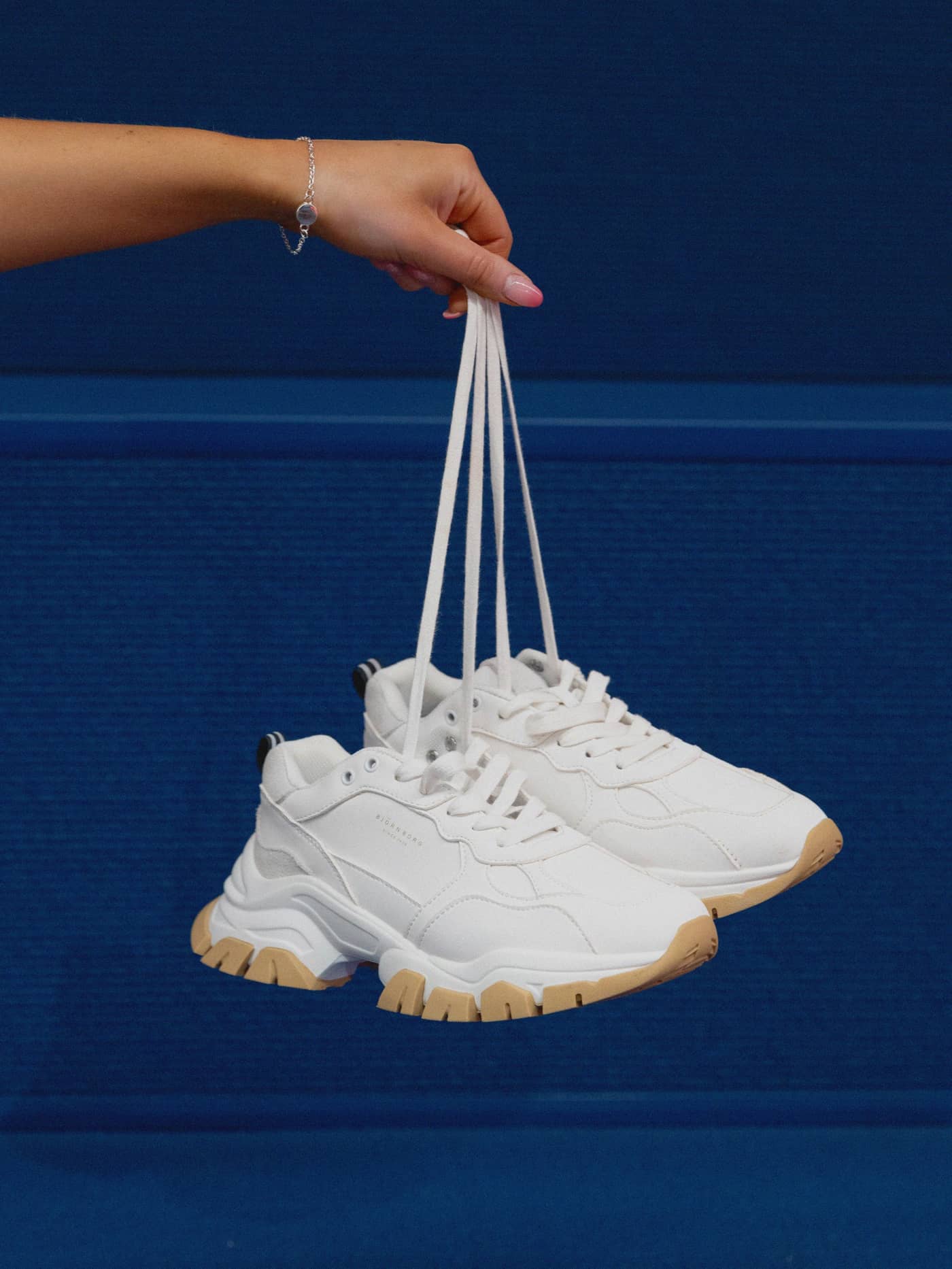Women's Sneaker R2600 Bsc in White held by laces, featuring a chunky training design in synthetic leather and textile. - Image 1