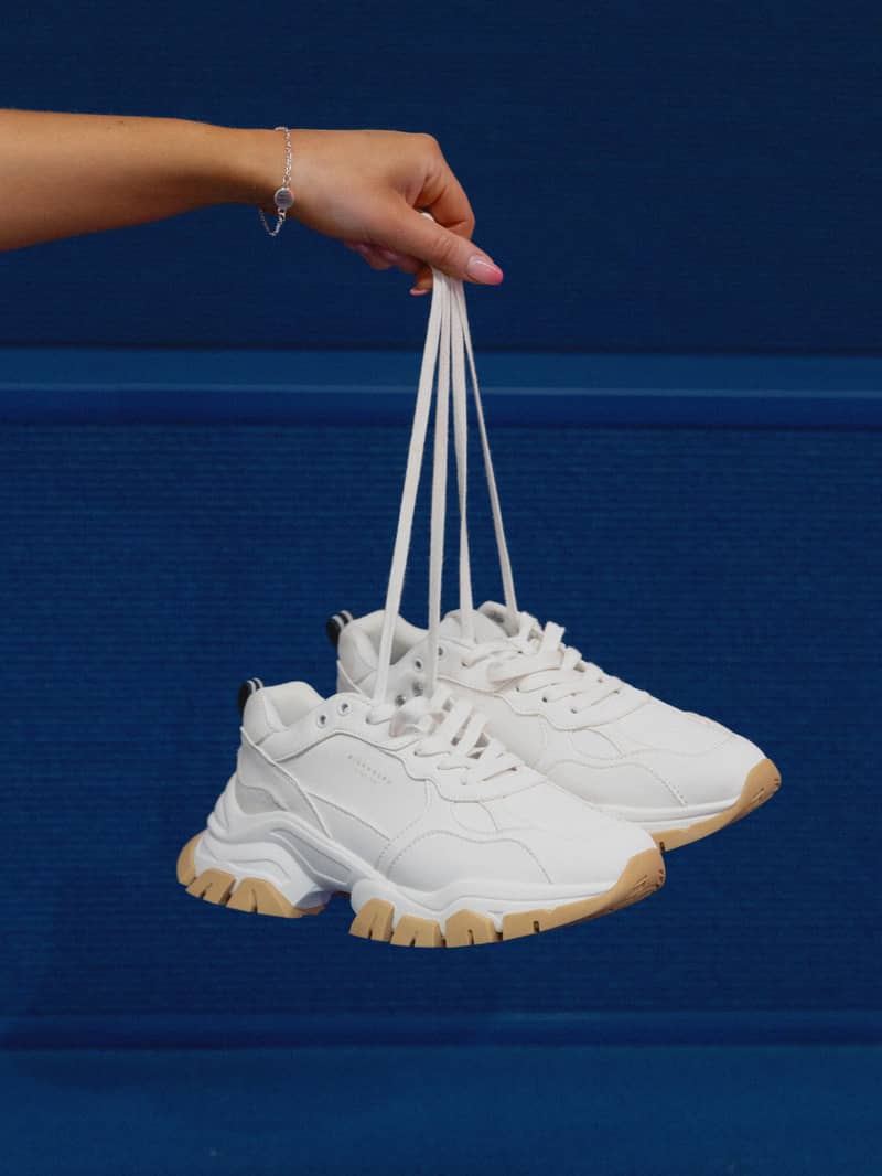 Women's Sneaker R2600 Bsc in White held by laces, featuring a chunky training design in synthetic leather and textile.