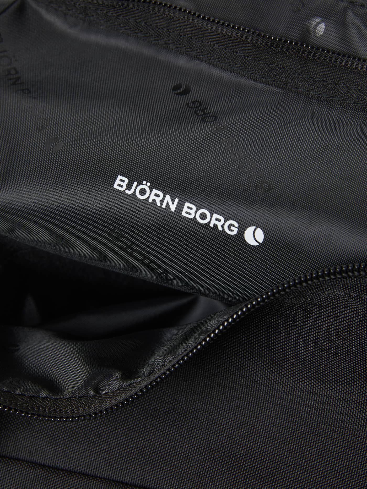 Gros plan du Core Sports Bag 31L en Black Beauty (Noir) pour l'entraînement avec logo blanc et doublure à motifs. - Image 5