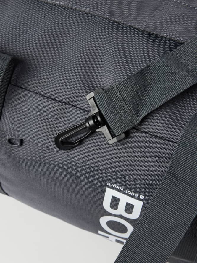 Gros plan du Core Sports Bag 31L en Asphalt (Gris) avec mousqueton robuste et logo blanc pour le training. - Image 3