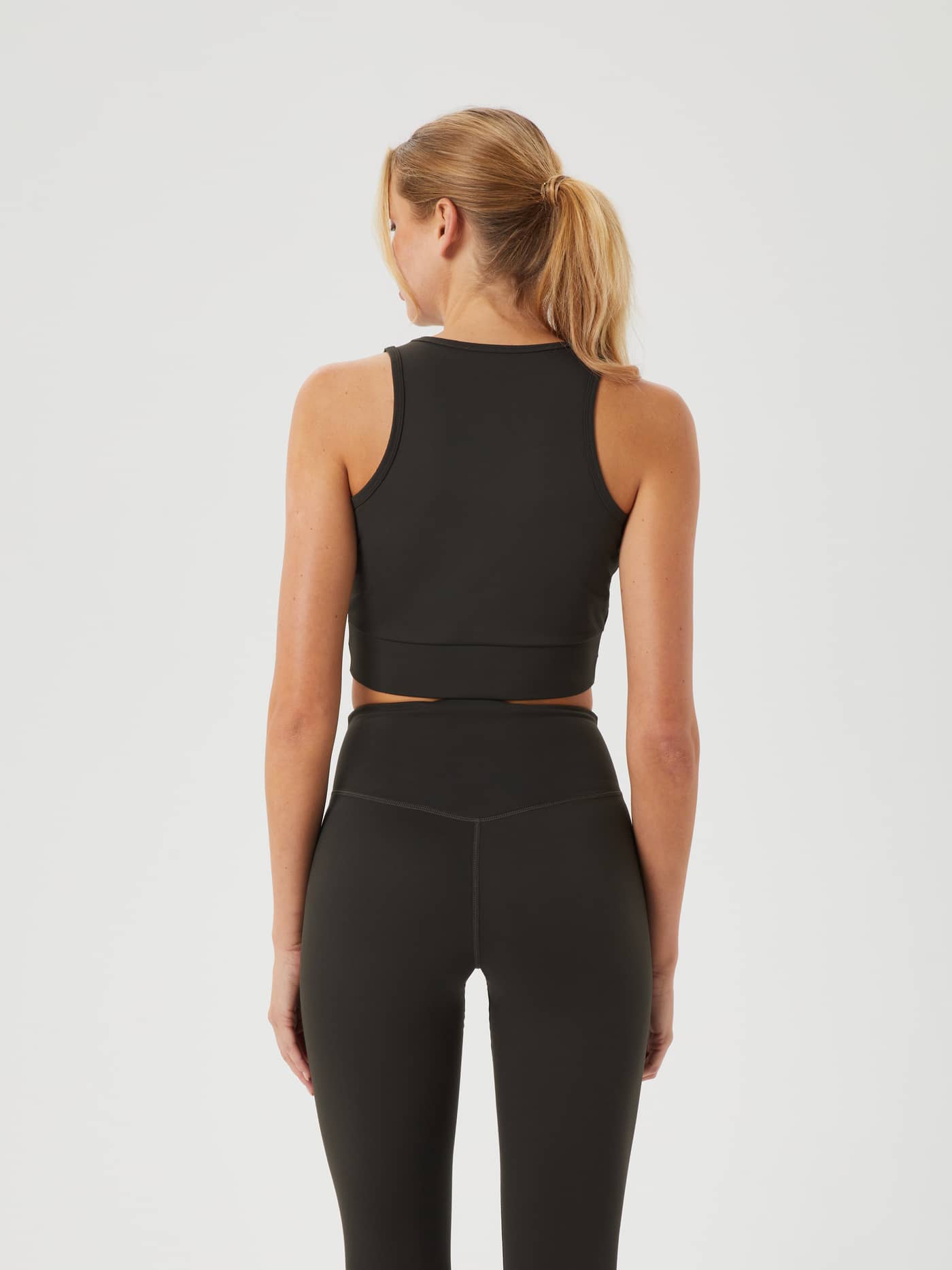 Back view of a woman wearing the Peat (Green) Björn Borg Studio Cross Tank, a functional training top for women. - Image 2