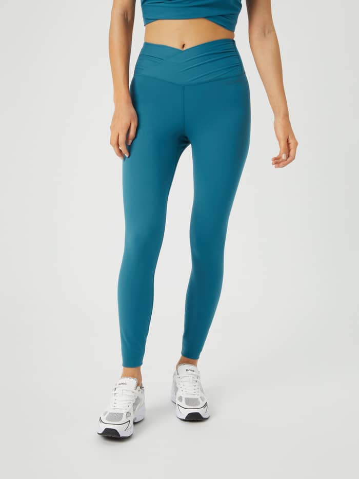 Front view of a model wearing Björn Borg Studio Cross Tights in Mallard Blue (Blue), featuring a twisted waist for training. - Image 2