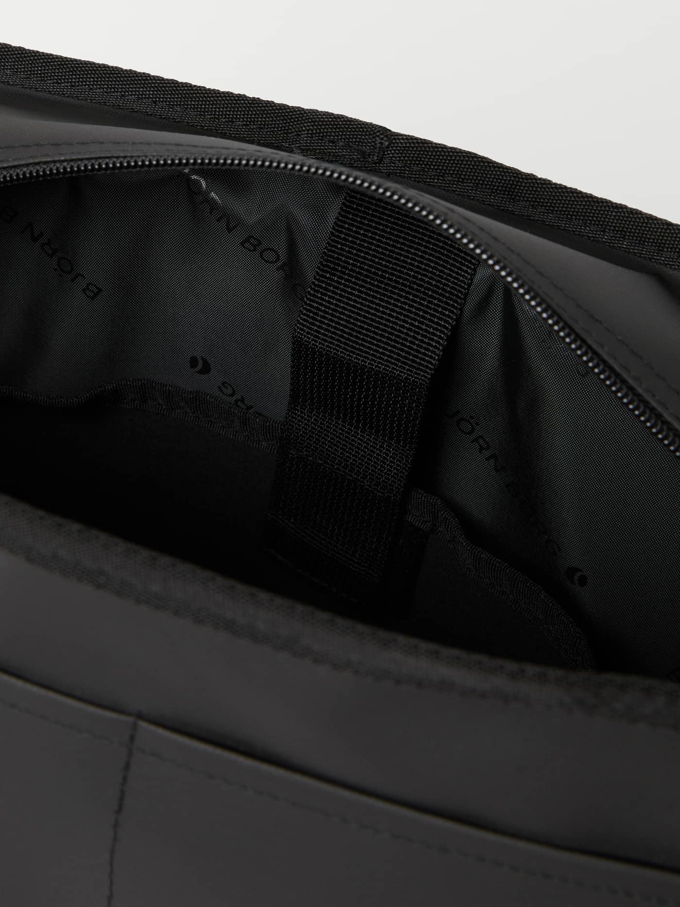 Interieurdetail van de Borg Duffle Messenger Bag 12L in Zwart met gevoerde laptopsleeve en logo-voering. - Image 5