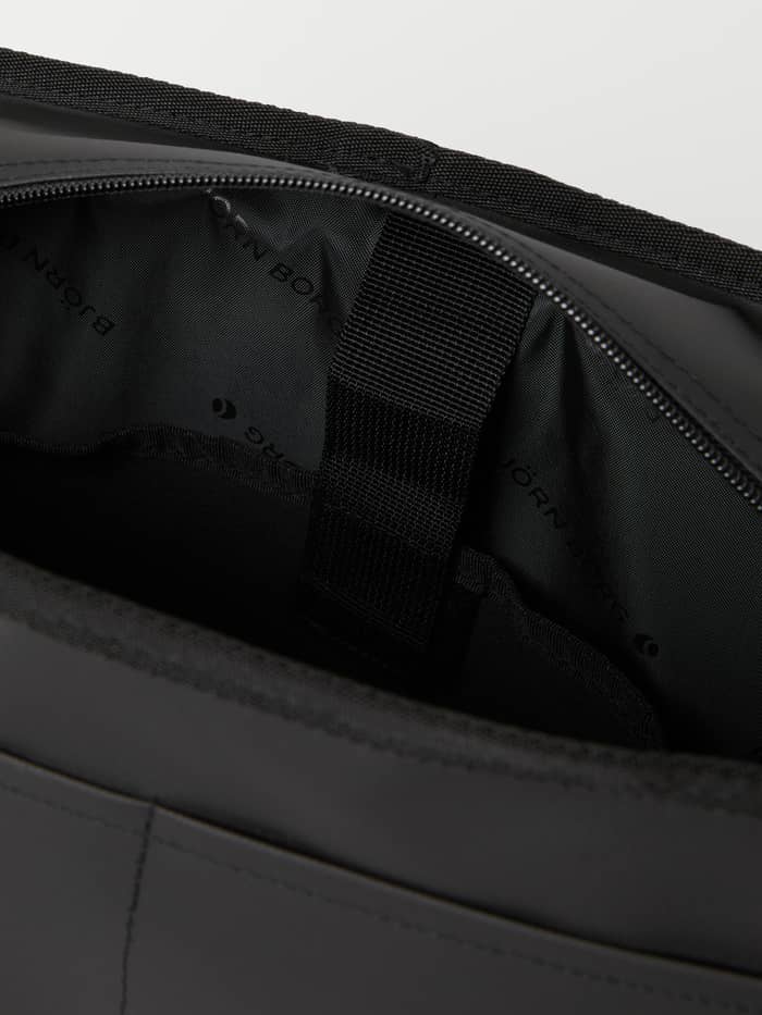 Interior detail of the Borg Duffle Messenger Bag 12L in Black, featuring a padded digital sleeve and logo lining. - Image 5