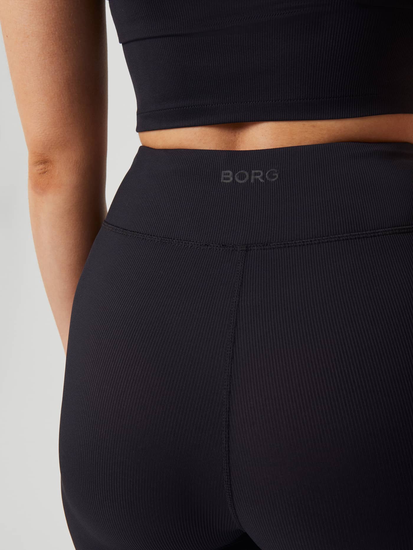 Studio Highwaist Rib Tights in Black Beauty (Zwart) met tonaal BORG-logo voor training, close-up van de achterkant. - Image 4