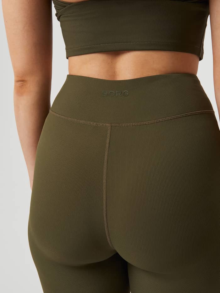 Back view of the Studio Highwaist Rib Tights in Olive Night (Green), featuring a ribbed texture and tonal Borg logo. - Image 5