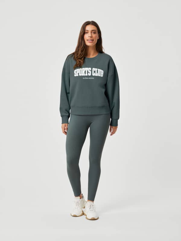 Vista frontal de una mujer con Studio Highwaist Rib Tights en Urban Chic (Verde) de ajuste entallado para entrenamiento.