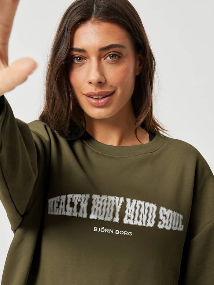 Vue de face du ACE BOYFRIEND CREW Olive (Vert), un sweat de tennis oversize pour femme avec un graphique blanc.