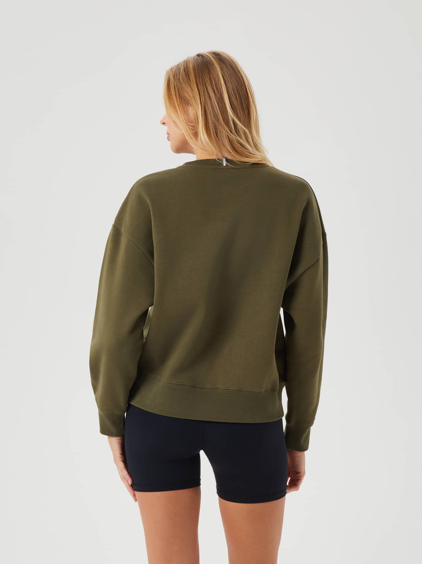 Back view of a woman wearing the Björn Borg Ace Boyfriend Crew in Olive Night (Green) for an oversized, relaxed fit. - Image 6