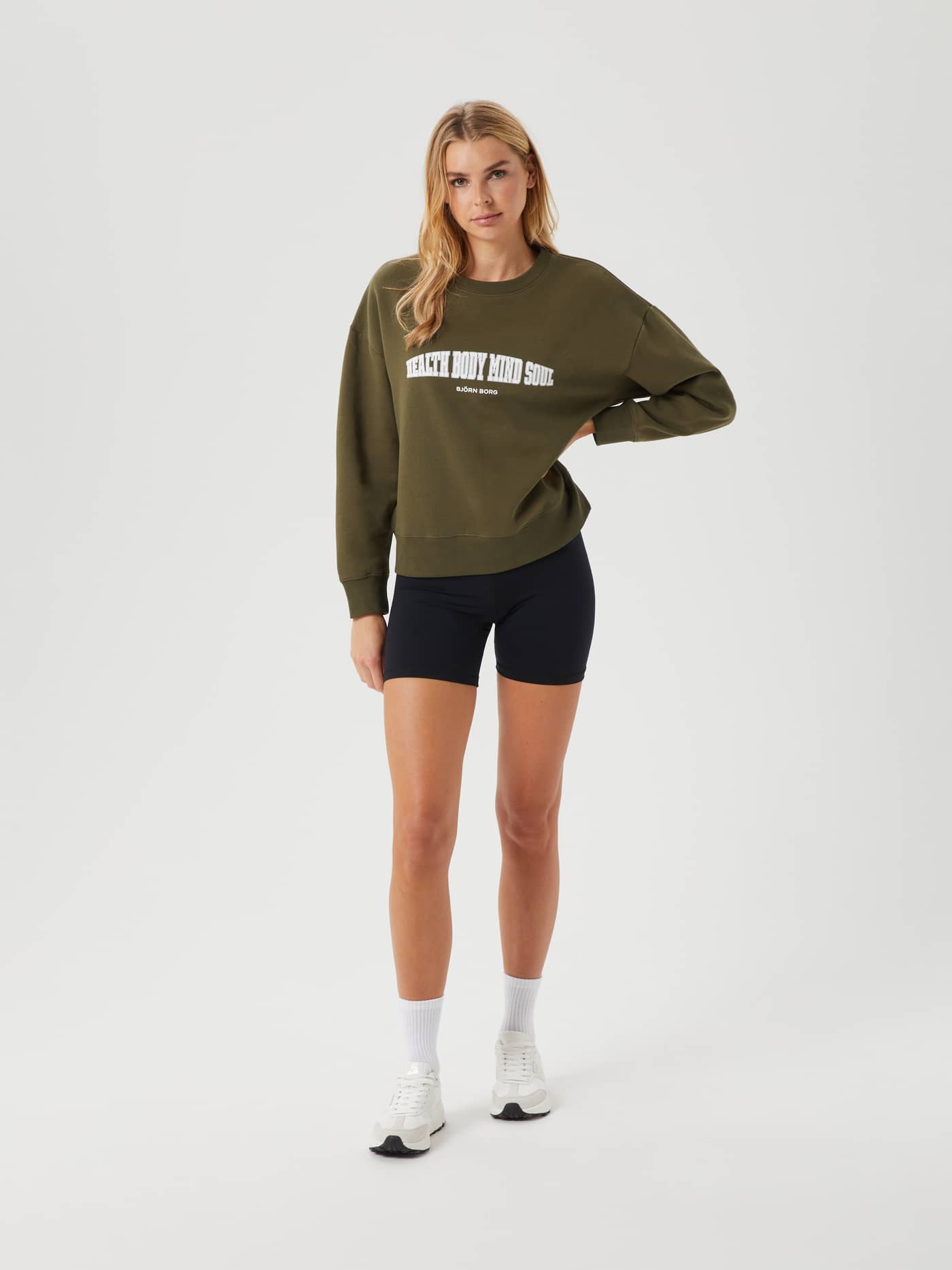 Full-body front view of a woman wearing the oversized Ace Boyfriend Crew in Olive Night (Green) with a white chest print. - Image 7