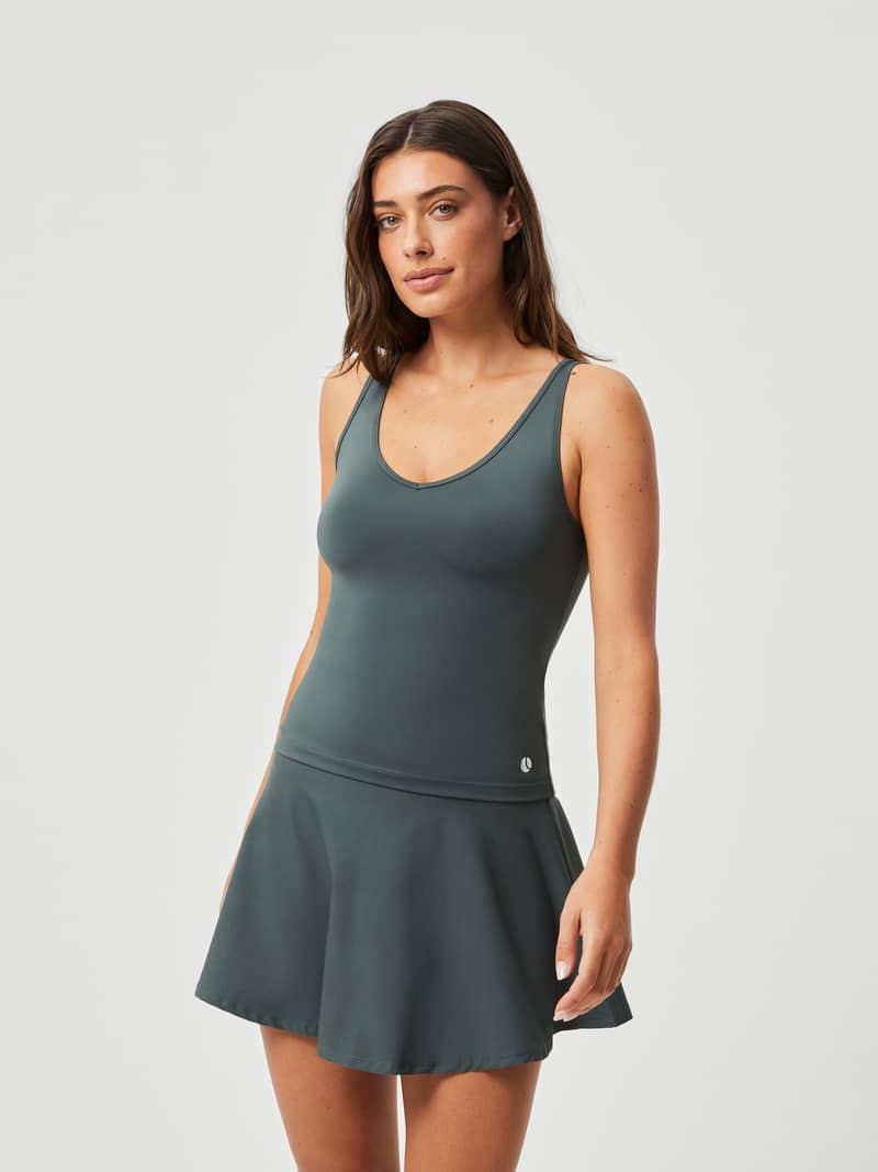 Front view of a woman wearing the Björn Borg Ace Deep V Tank in Urban Chic (Green), a slim-fit top for tennis performance.