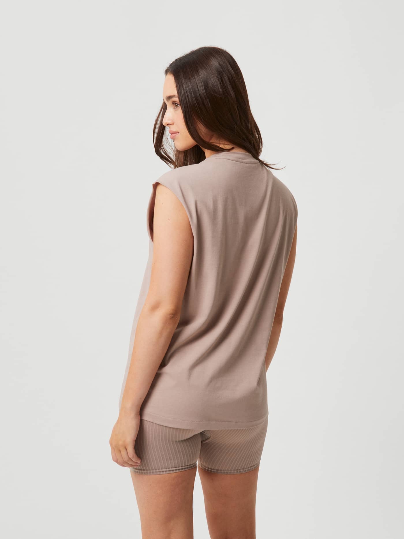 Studio Loose Fit Tank i Etherea (Beige) sett bakfra, en myk treningstopp for kvinner med løs passform. - Image 2