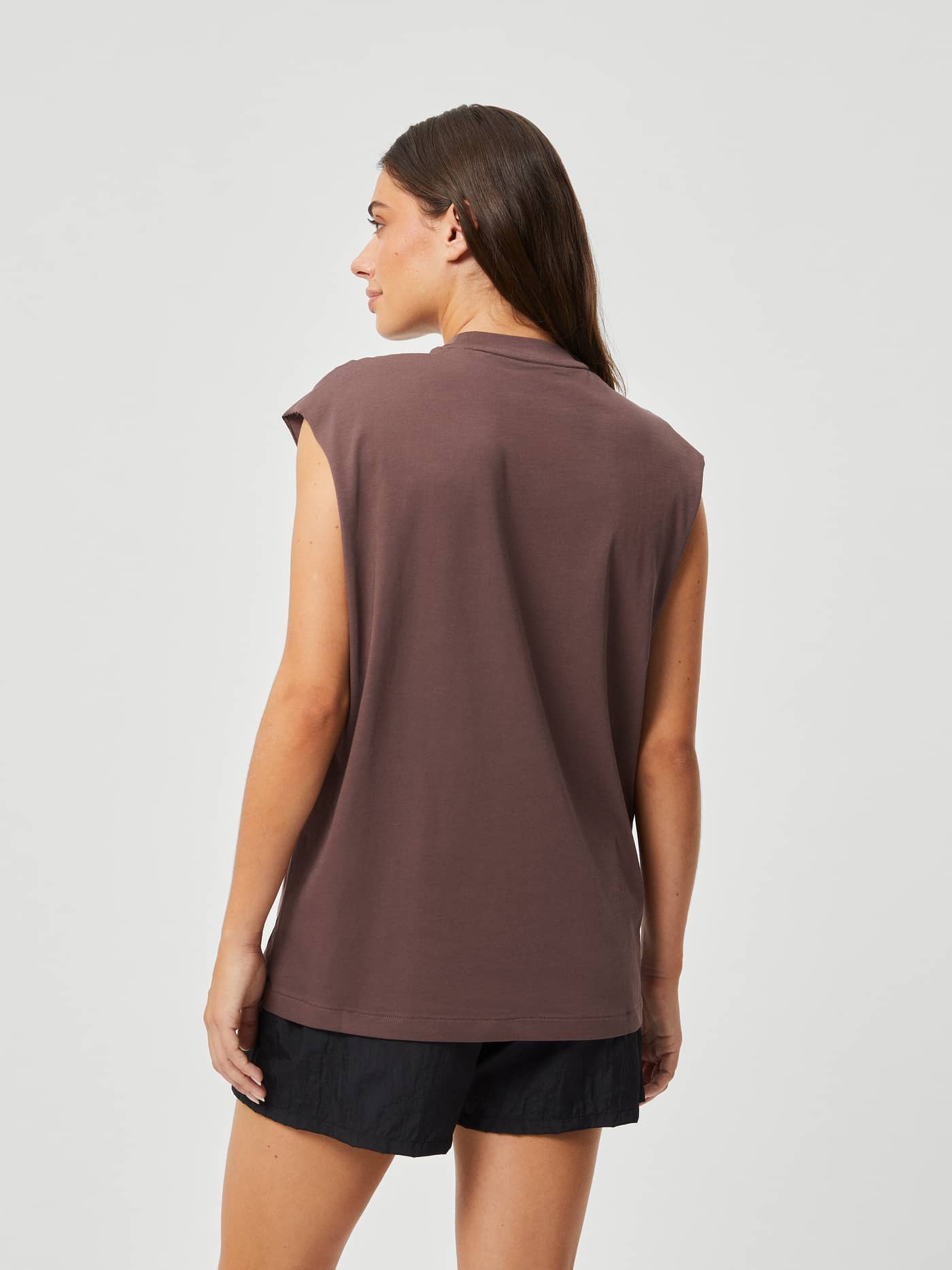 Back view of a woman wearing the Björn Borg Studio Loose Fit Tank in French Toast (Brown) for training. - Image 2