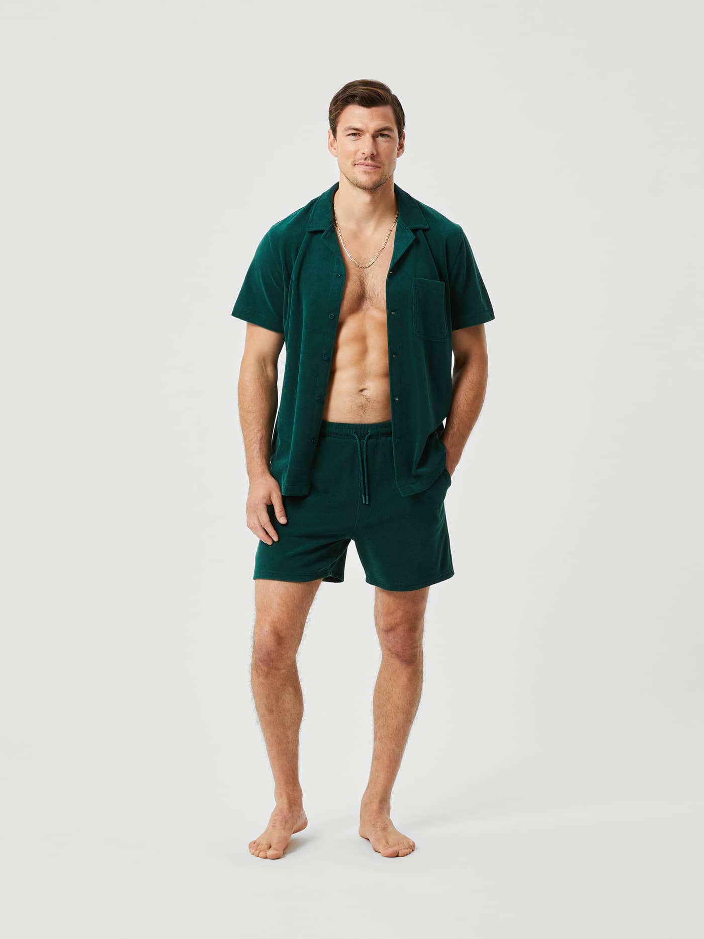 Volledig vooraanzicht van een man in de Borg Toweling Pool Shorts in Ponderosa Pine (Groen) van zachte badstof. - Image 3