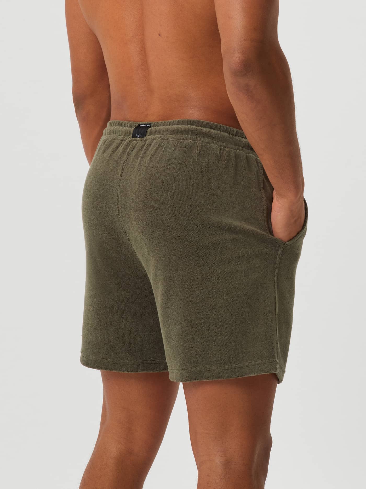 Vy bakifrån på en man i Beetle (Grön) Borg Toweling Pool Shorts i mjuk frotté för stil och funktion. - Image 2