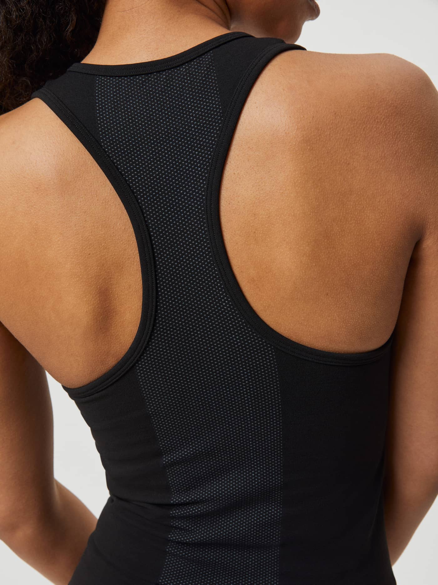 Close-up van de ademende racerback van de Borg Running Seamless Tank in Black Beauty (Zwart) met naadloze pasvorm. - Image 6
