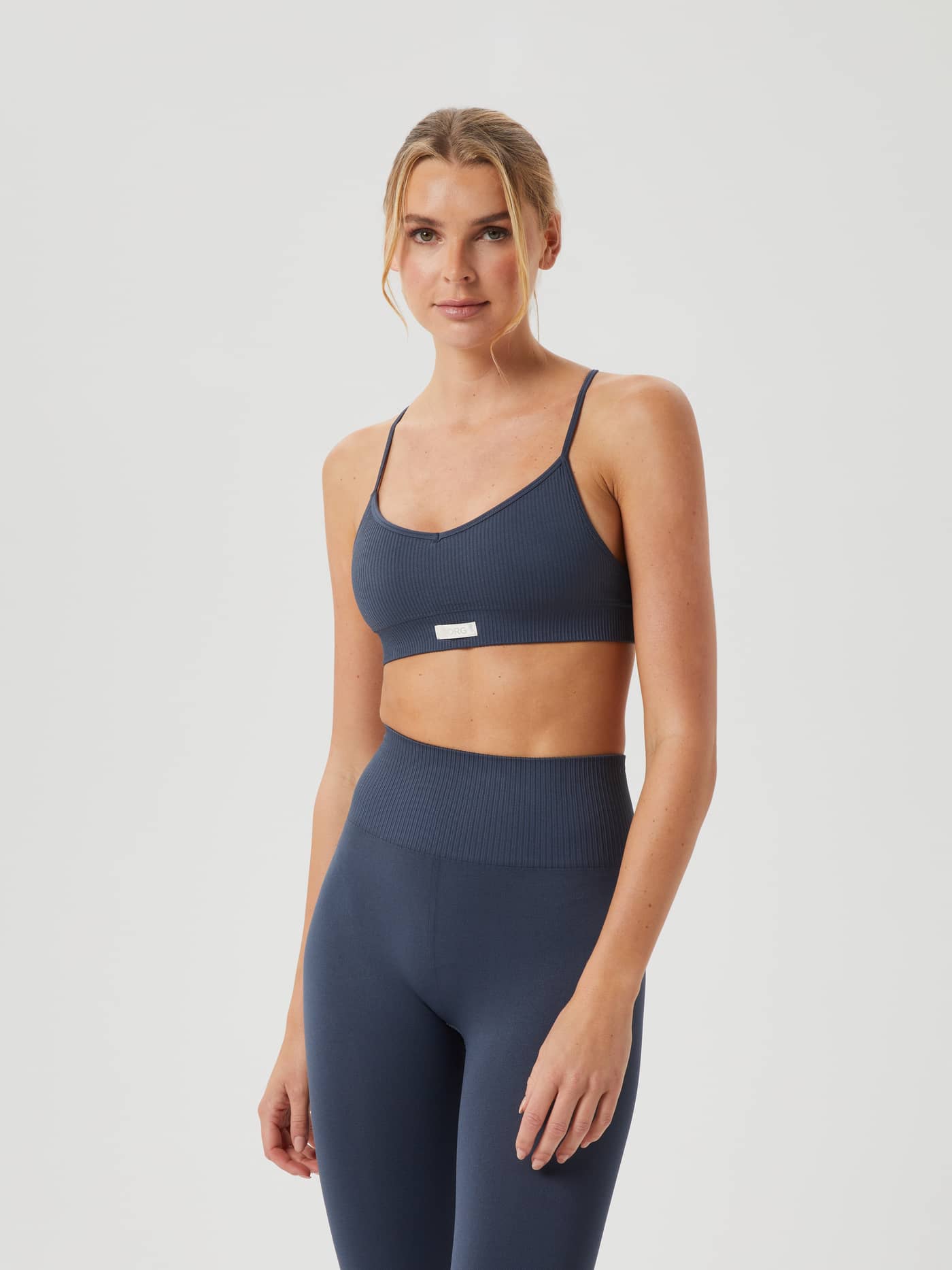 Front view of a woman wearing the navy Studio Seamless Ribbed Strap Bra featuring a stylish, soft and supportive fit. - Image 2