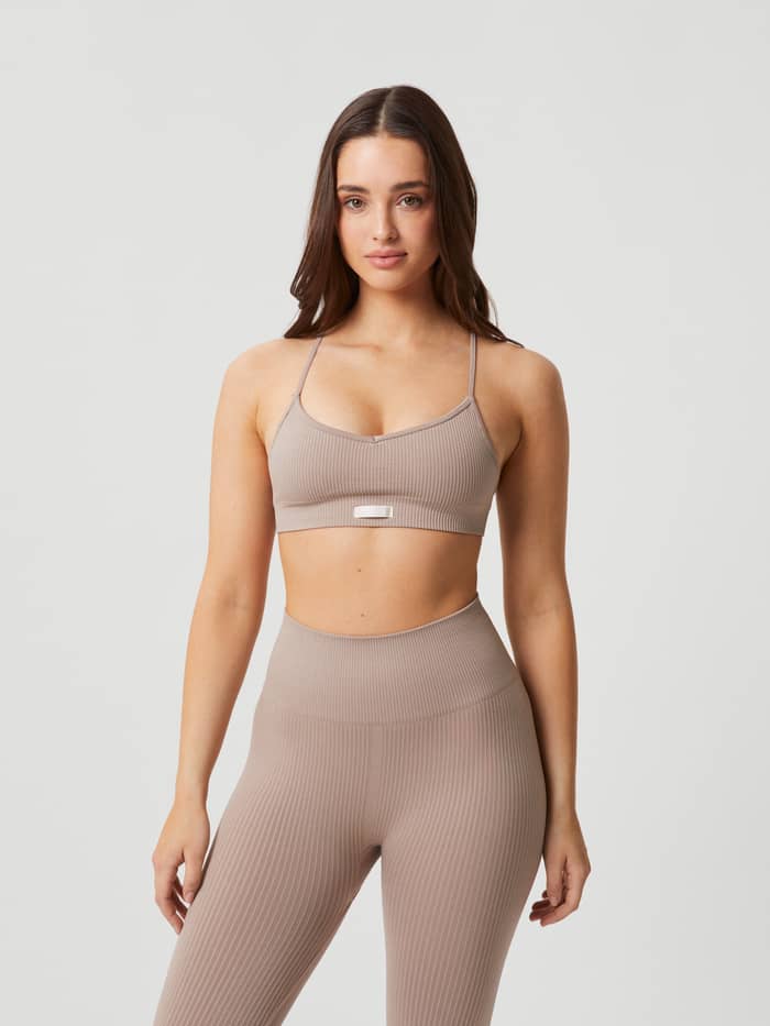 Modell framifrån i Studio Seamless Ribbed Strap Bra i Beige för dam, en ribbad och sömlös sport-bh för stilren träning.
