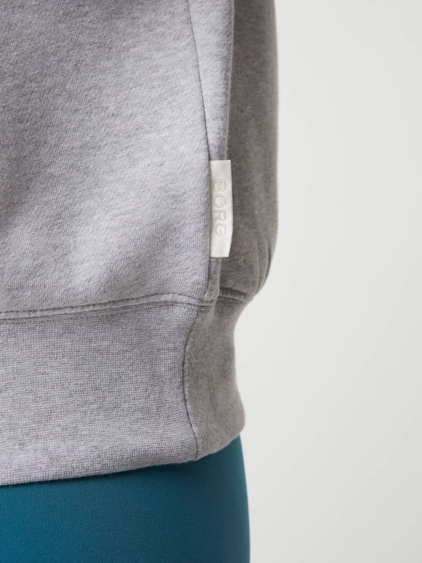 Studio Oversized Crew i Light Grey Melange (Grå) til dame med hvit vevd logolapp på siden, nærbilde i myk bomull. - Image 5
