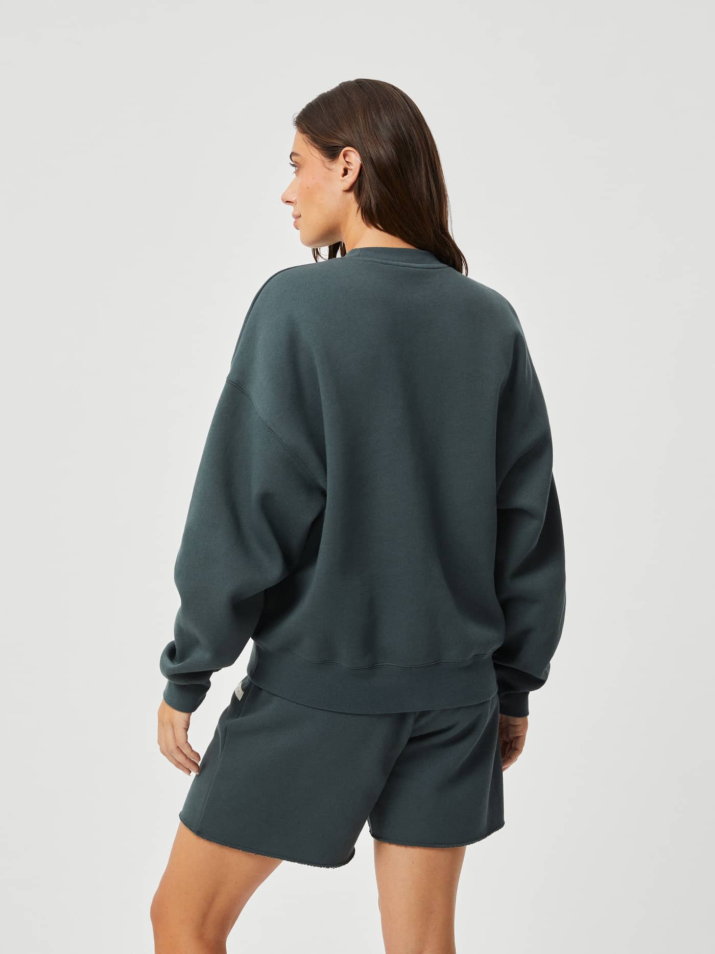 Back view of a woman in the Björn Borg Studio Oversized Crew in Urban Chic (Green), with a relaxed, dropped shoulder fit. - Image 2