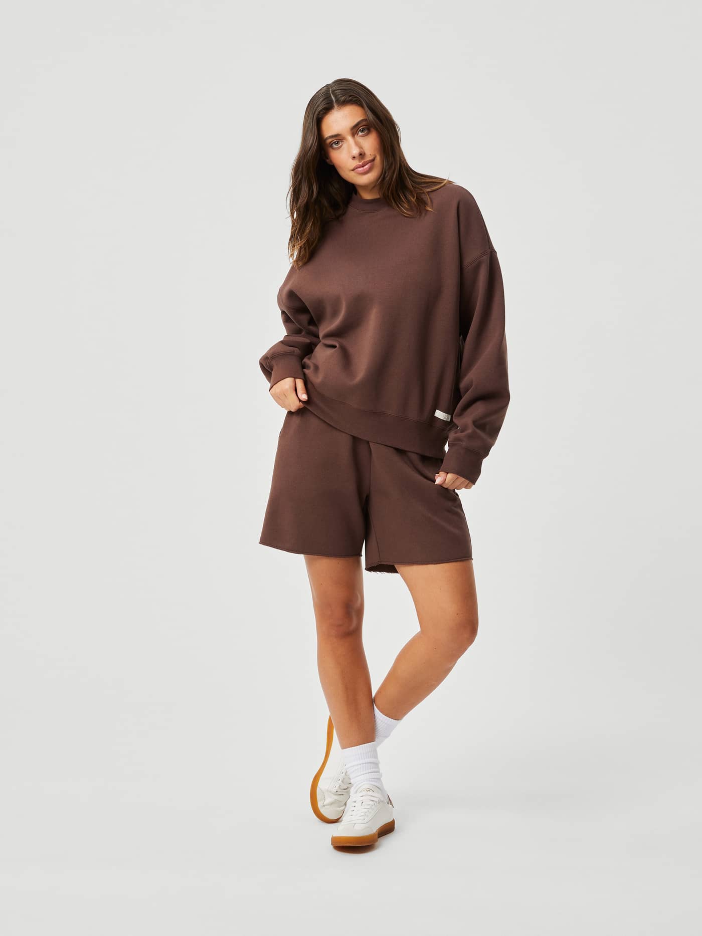 Full-body front view of a woman in the Björn Borg Studio Oversized Crew in French Toast (Brown) with a stylish, relaxed fit. - Image 4