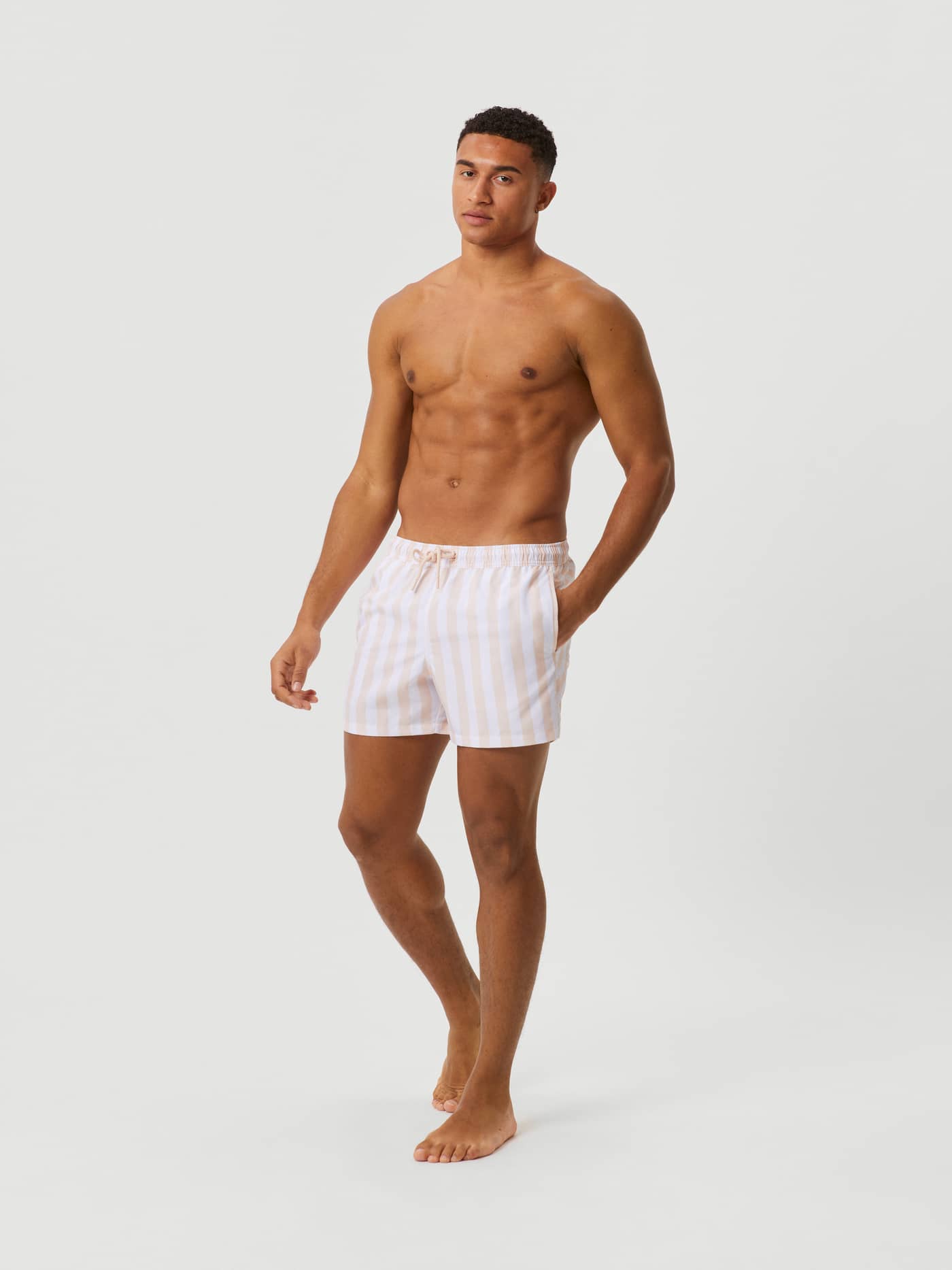 Vooraanzicht van een man in de sneldrogende Borg Print Swim Shorts in Sunny Stripe 1 (Roze) met verticale strepen. - Image 2