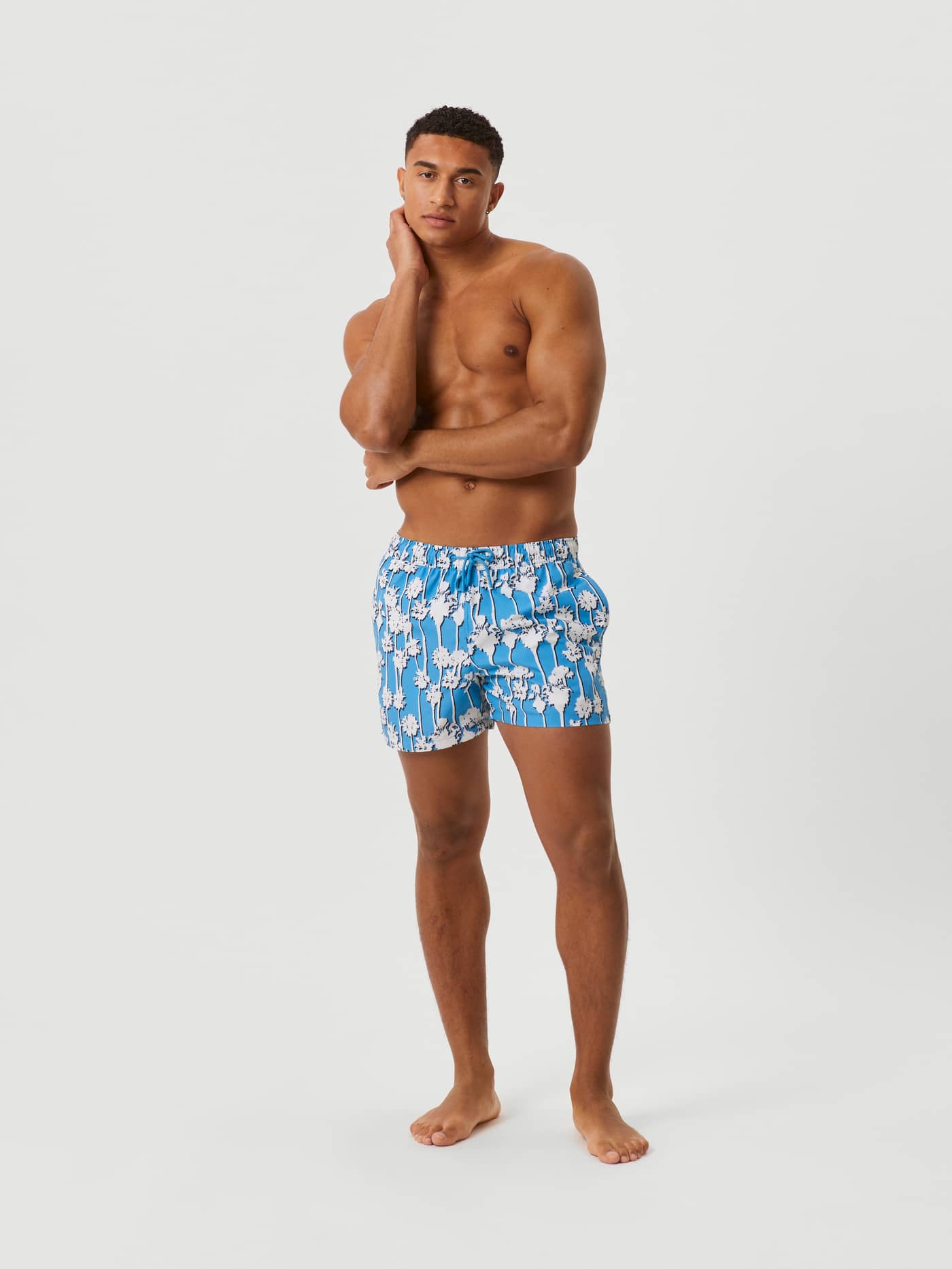 Mann i Borg Print Swim Shorts i Palm Springs Big 1 (Blå) med palmetre-mønster sett forfra i full lengde. - Image 1
