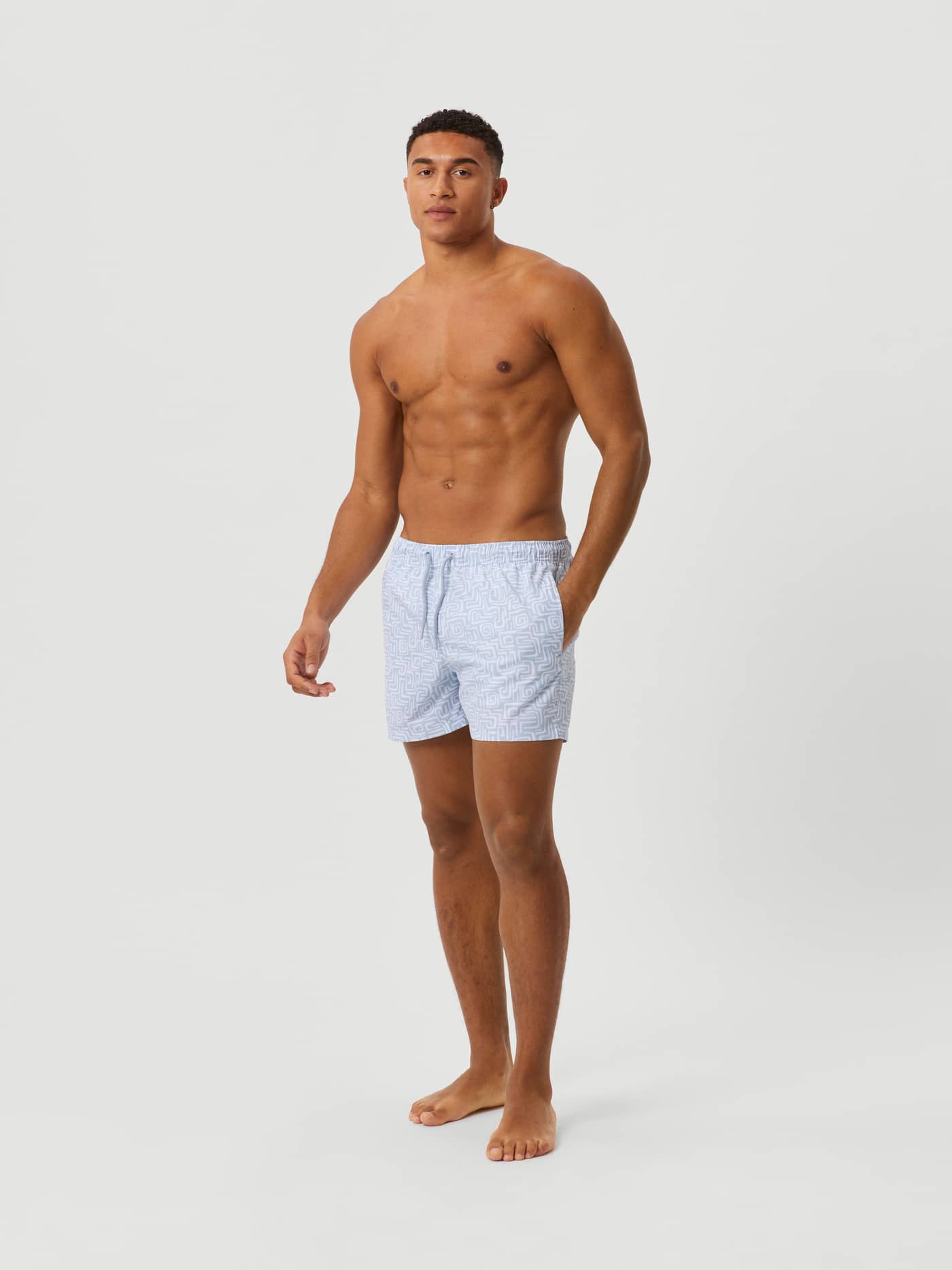 Full-body view of a man wearing the quick-drying Borg Print Swim Shorts in Funky Big 1 (Blue) with a graphic pattern. - Image 2
