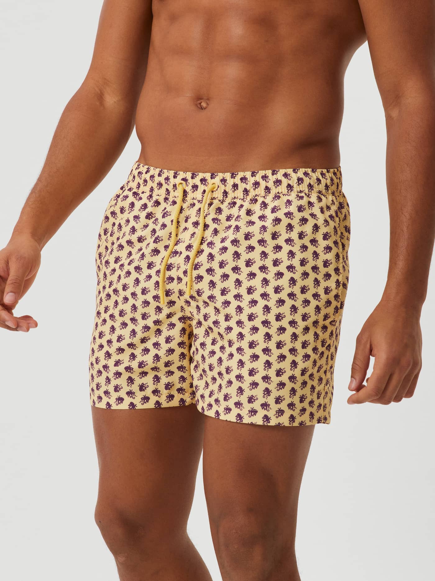 Front view of a man wearing the quick-drying Borg Print Swim Shorts in Octo 2 (Yellow) with a purple octopus print. - Image 2