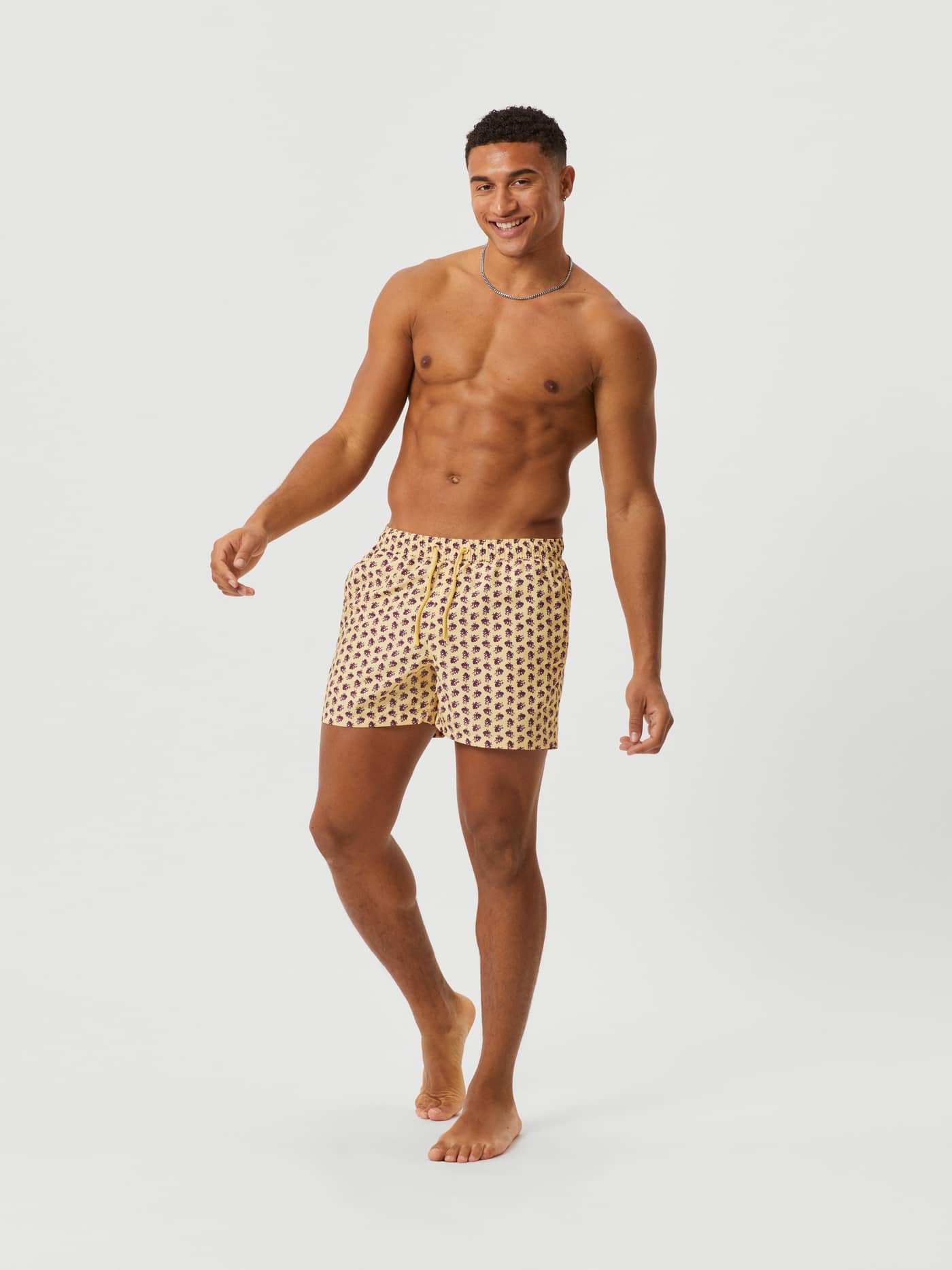 Full-body front view of a man wearing the loose-fit Björn Borg Print Swim Shorts in Octo 2 (Yellow). - Image 1