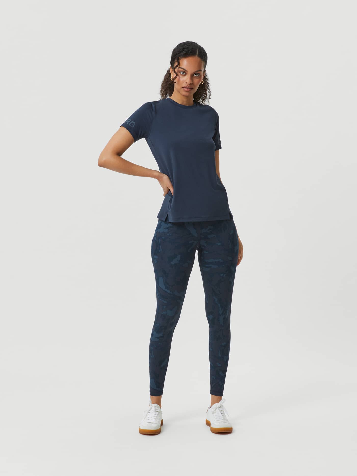 Full-body front view of a model wearing navy Björn Borg Printed Tights with a camo pattern for a stylish training fit. - Image 1