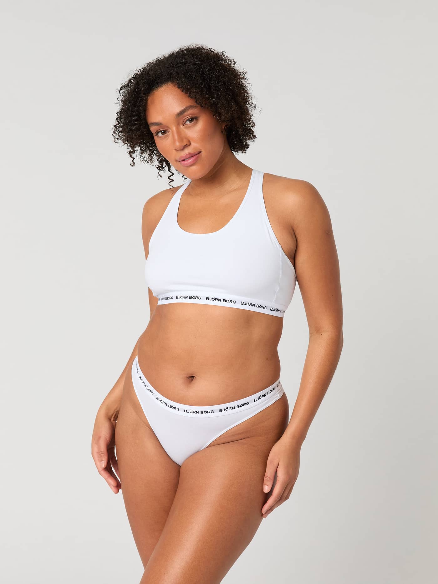 Core Logo Thong 2-pack in Wit van zacht stretchkatoen met een zwarte logotailleband in vooraanzicht op een model. - Image 10