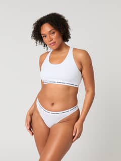 Core Logo Thong 2-pack in Wit van zacht stretchkatoen met een zwarte logotailleband in vooraanzicht op een model. - Image 10