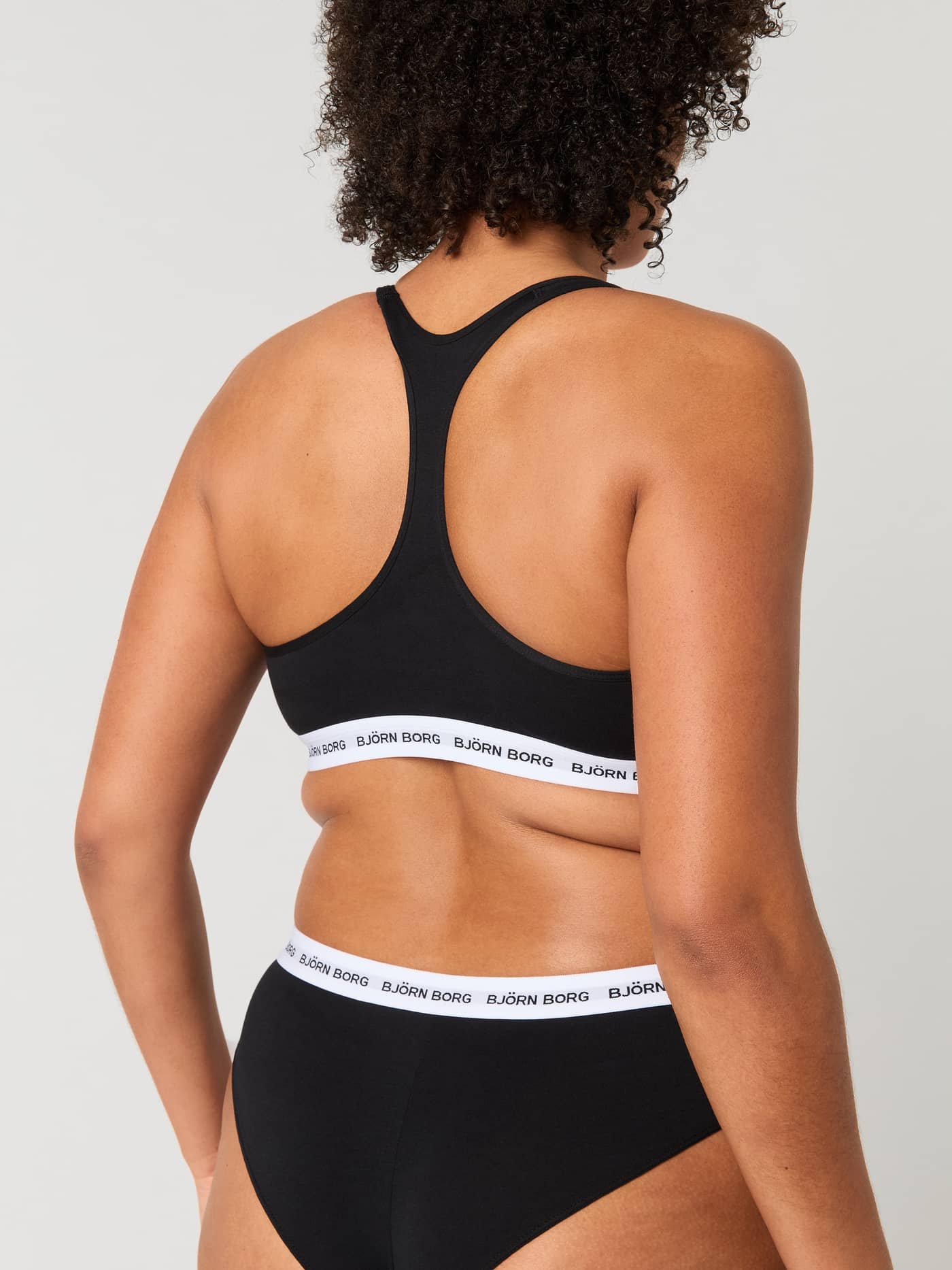 Vista posterior de mujer con el Björn Borg Core Logo Soft Top 1-pack en Negro de algodón elástico suave con espalda nadadora. - Image 4
