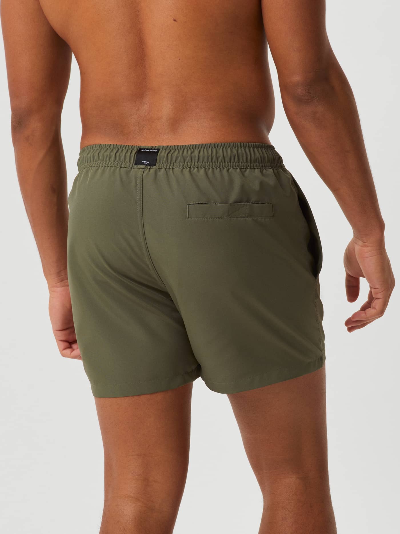 Vista trasera del funcional Borg Solid Swim Shorts en Beetle (Verde) con bolsillo trasero con velcro. - Image 3