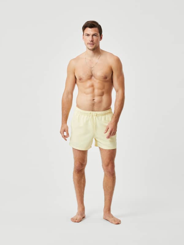 Borg Solid Swim Shorts i French Vanilla (Gul) set forfra i fuld figur med løs pasform og snøre i taljen.