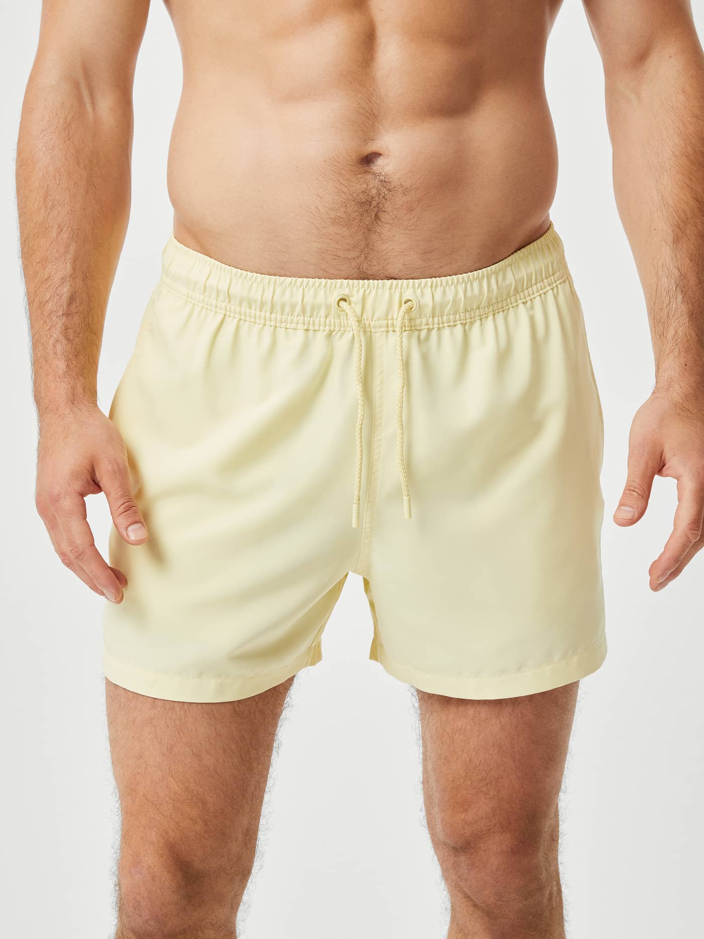 Vue de face d'un homme portant le Borg Solid Swim Shorts ample en French Vanilla (Jaune) en polyester recyclé. - Image 2