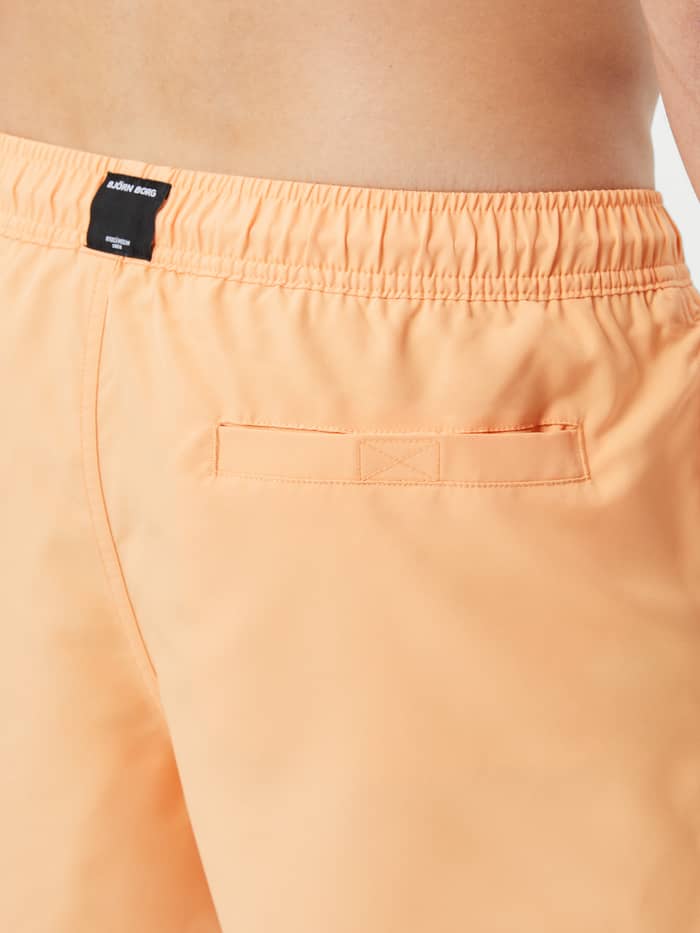 Borg Solid Swim Shorts in Orange Chiffon (Oranje) in achteraanzicht met een achterzak met klittenband en logolabel. - Image 4