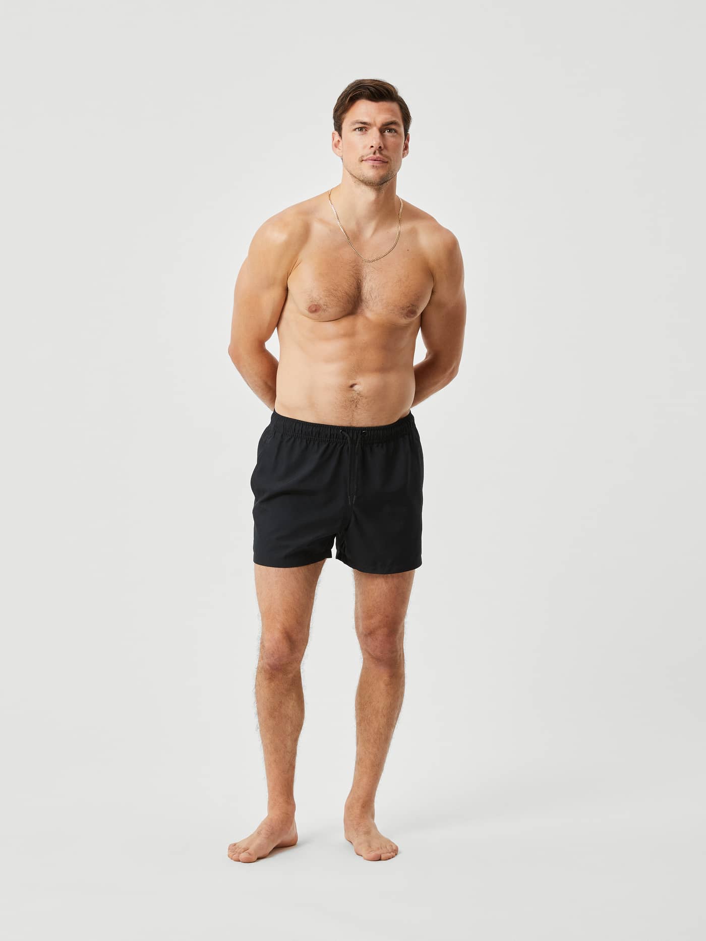 Mand i helfigur set forfra iført Borg Solid Swim Shorts i Black Beauty (Sort) med en justerbar snøre. - Image 1