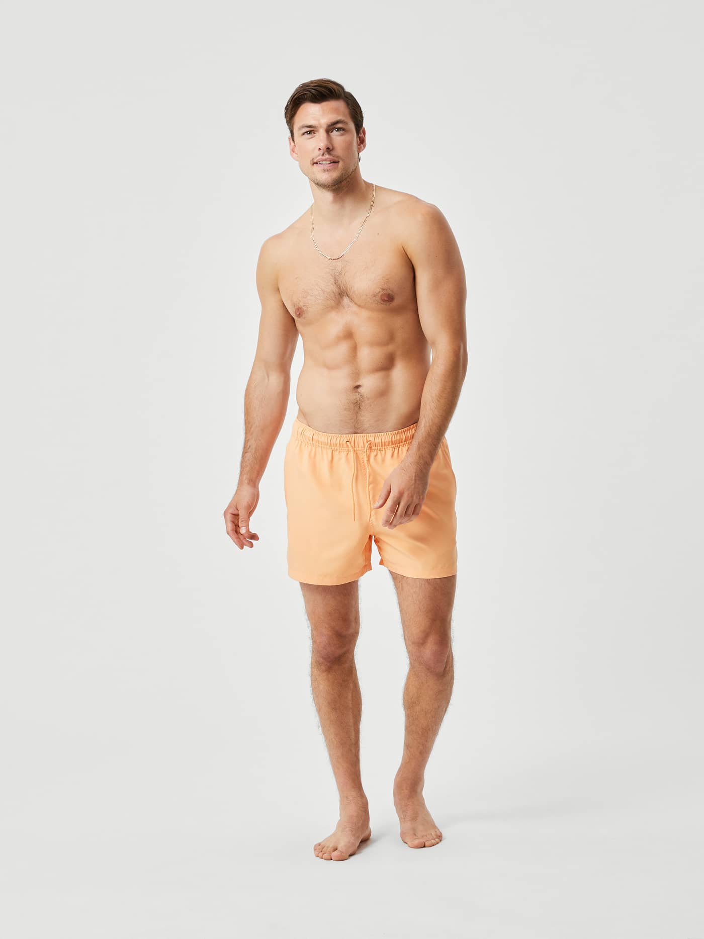 Full-body front view of a model wearing the stylish and functional Borg Solid Swim Shorts in Orange Chiffon (Orange). - Image 1