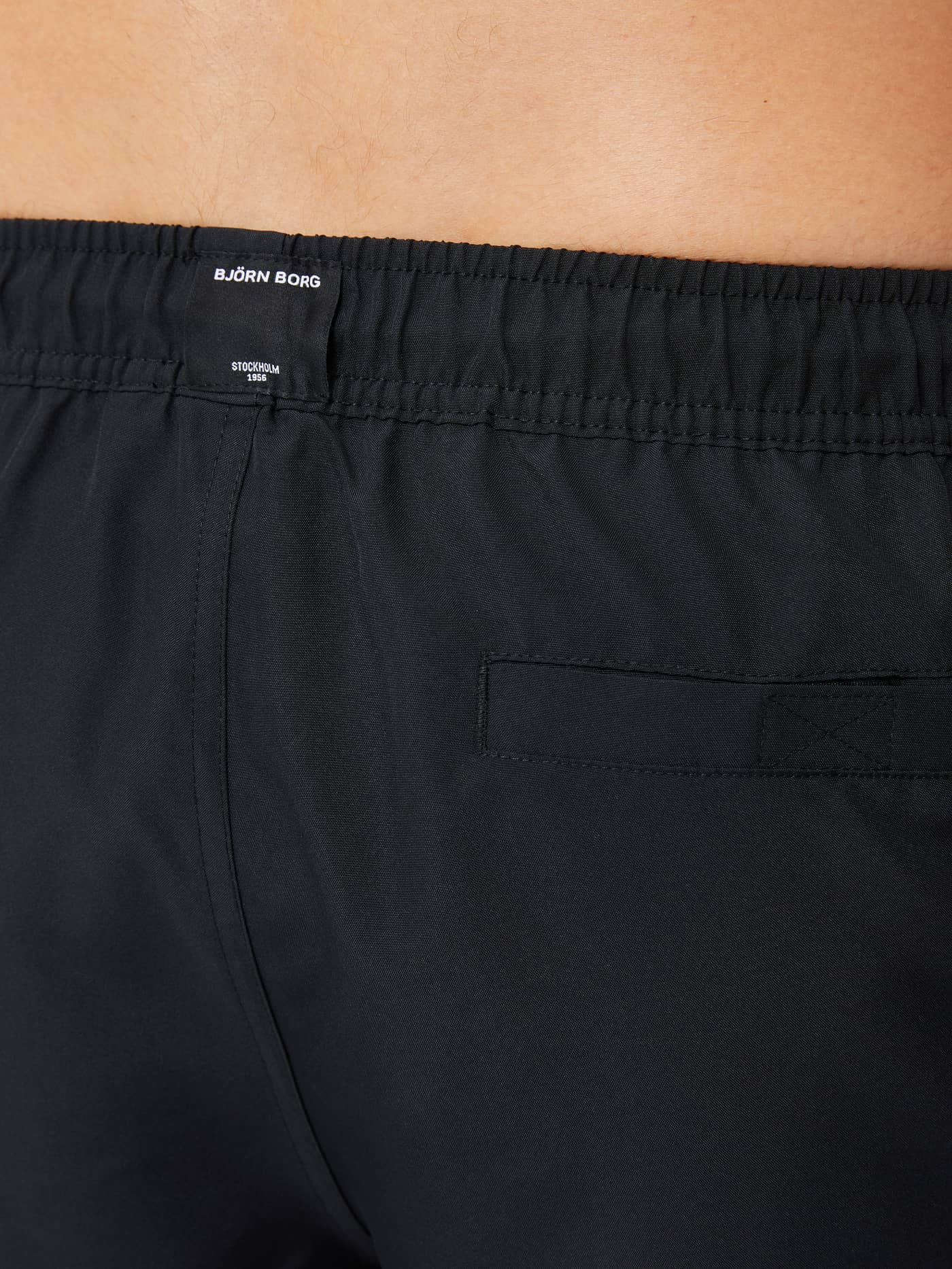 Borg Solid Swim Shorts i Black Beauty (Sort) set bagfra med funktionel velcro-baglomme og hvidt logo. - Image 4