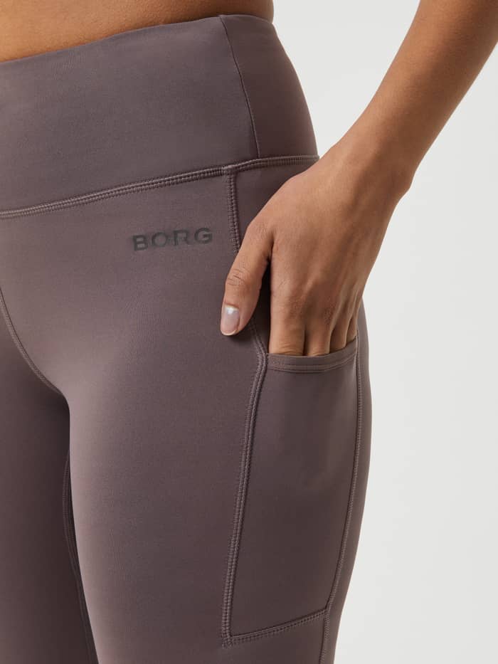 Detailed close-up of the Sparrow (Brown) Borg Running Tights for women, featuring a side pocket and grey BORG logo. - Image 4