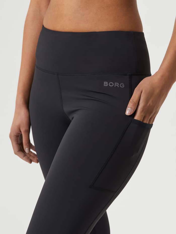 Close-up of the slim-fit Borg Running Tights for women in Black Beauty (Black) featuring a side pocket and tonal logo. - Image 4