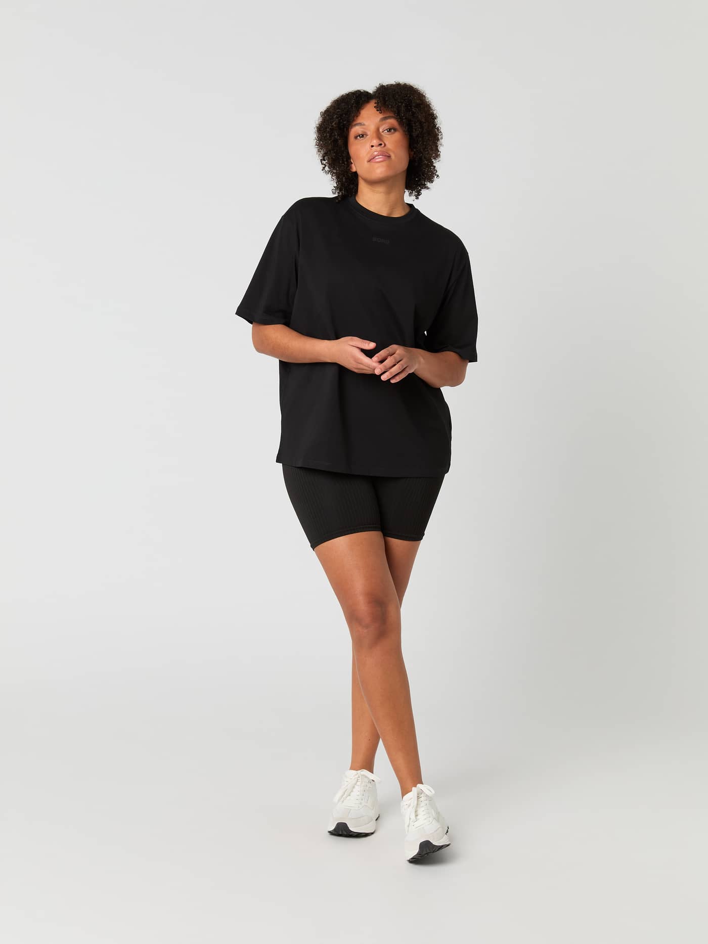 Front view of a woman in the Björn Borg Studio Oversized T-Shirt in Black Beauty (Black) with a black logo for training. - Image 3