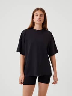 Front view of a woman wearing the Björn Borg Studio Oversized T-Shirt in Black Beauty (Black) with tonal logo for training. - Image 4