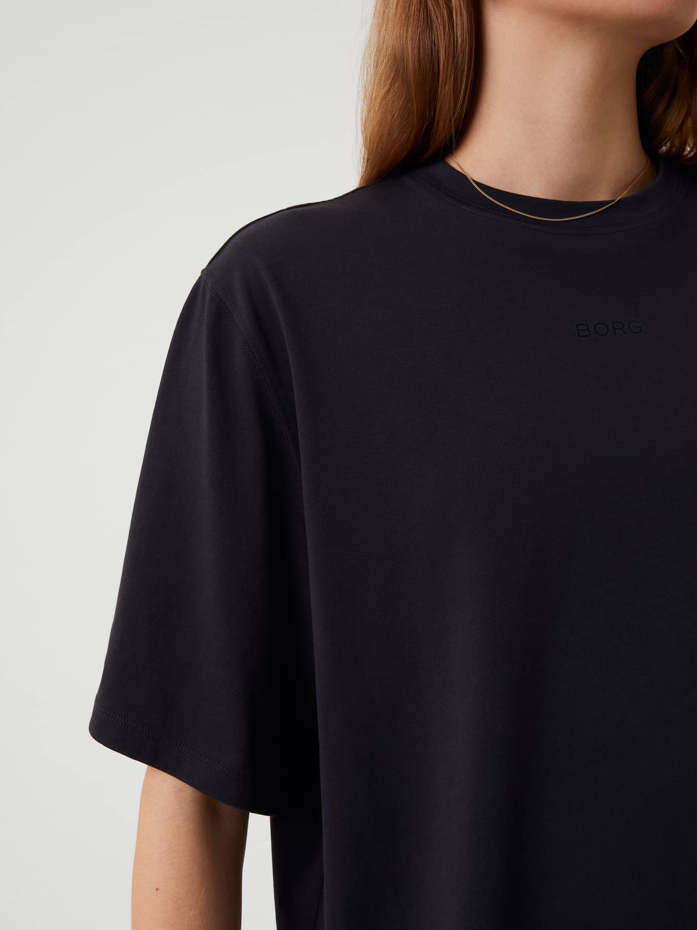 Close-up of the women's Björn Borg Studio Oversized T-Shirt in Black Beauty (Black) featuring a tonal logo for training. - Image 8