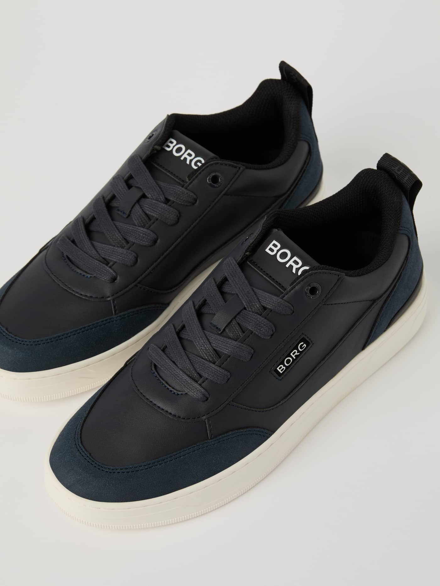 Men’s Sneakers T1055 i Navy i PU-læder med color blocking og en hvid tennissål set fra en skrå vinkel. - Image 1