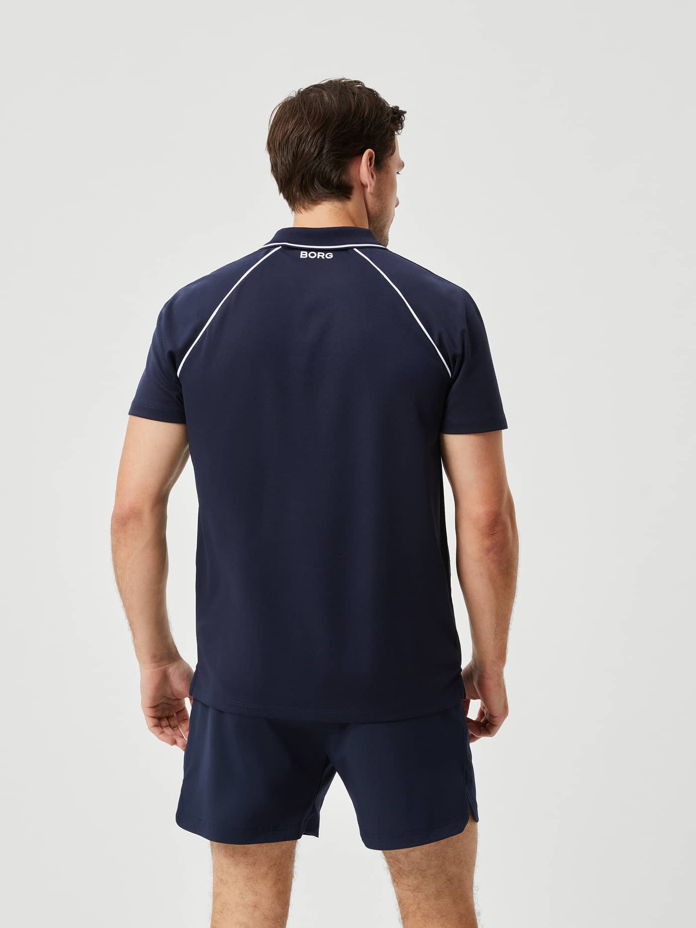 Back view of a man wearing the Björn Borg Ace Racquet Polo in Night sky (Blue) with contrast piping for tennis style. - Image 2