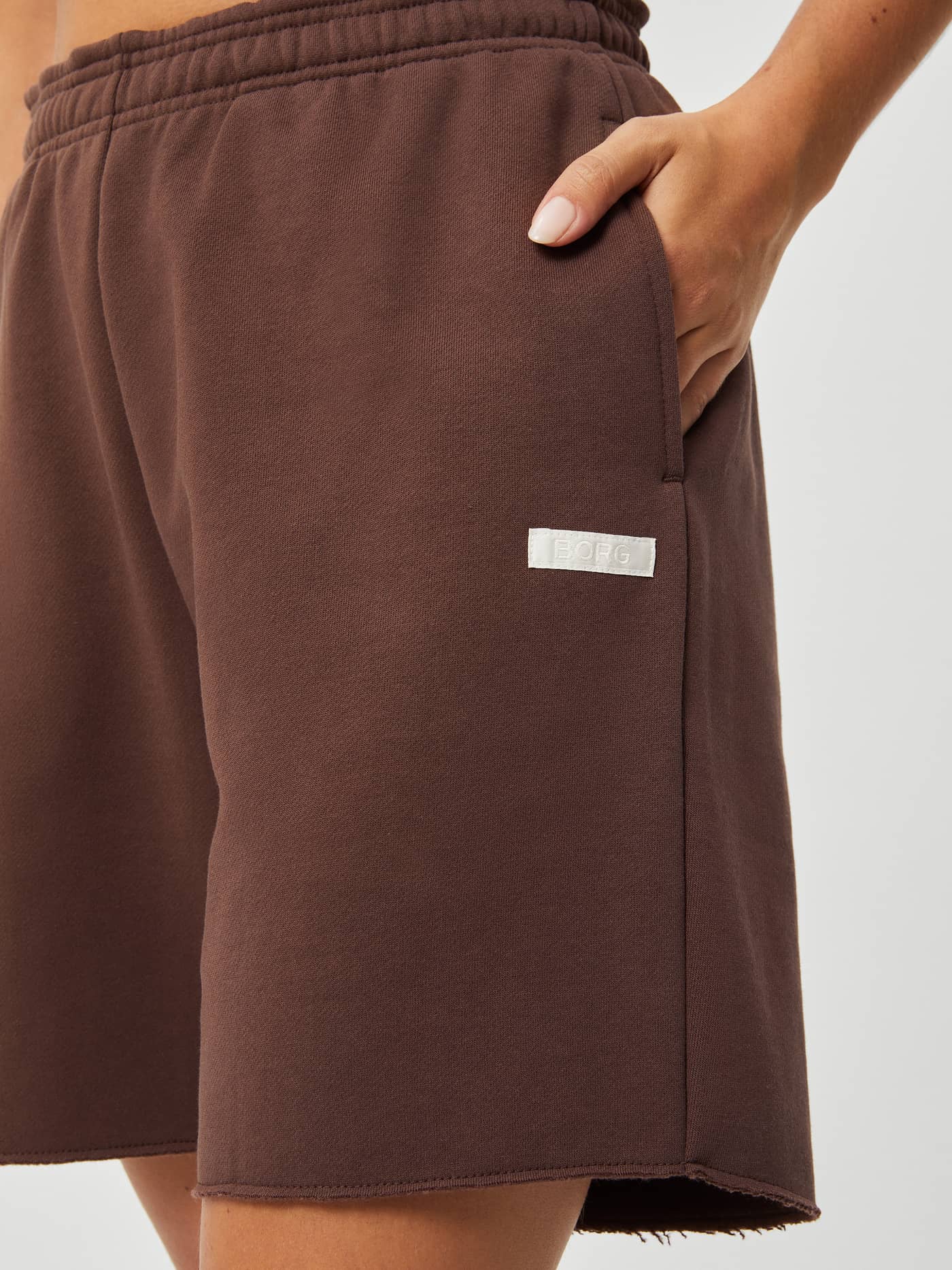 Detailed view of the soft Studio Oversized Shorts in French Toast (Brown) featuring a side pocket and white Borg logo label. - Image 6